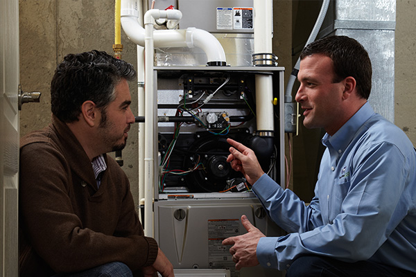 Rep and Customer with Heating Unit in Basement